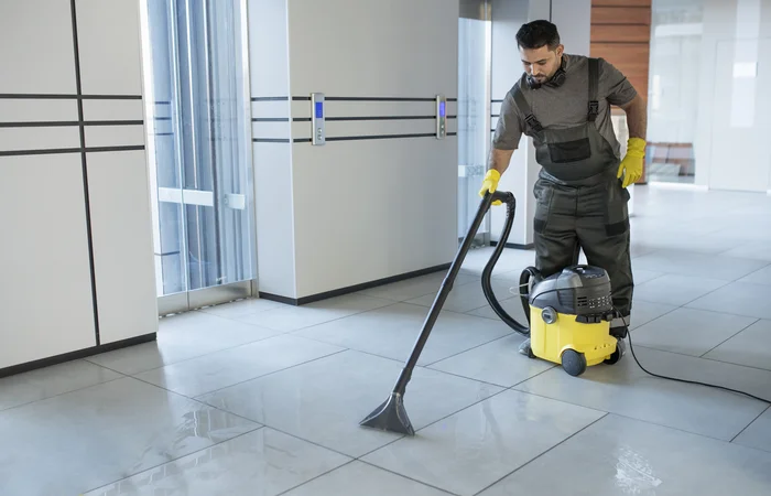 un homme qui nettoie le carrelage d'un maison